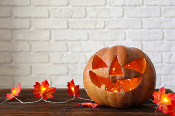 Wall Mural - Orange pumpkin carved into Jack o Lantern on wooden table. Background, copy space, close up, top view. All hallows eve Halloween party decoration. Trick or treat concept.