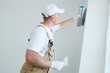 Painter with putty knife. Plasterer smoothing wall surface at home renewal