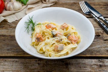 Wall Mural - fettuccine with salmon on wooden table