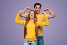 Cheerful Young Couple Flexing Muscles