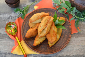 Homemade pies on rustic plate with russian spoon in khokhloma style