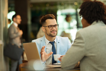 Young businessmen sitting at a coffee shop and talking about business