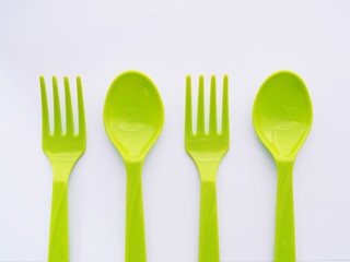 Wall Mural - Green Plastic Cutlery, Spoon and fork isolated on white background.