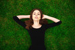© Andrey_Arkusha - Top view portrait of a young beautiful woman in black dress lies on green lawn in a park