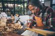 © chokniti - Background image of woodworking workshop: carpenters work table with different tools and wood cutting stand, vintage filter image