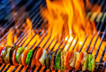 Kebabs mixed vegetables skewers flaming charcoal grill with open fire grilling barbecue