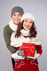 Wall Mural - Handsome young man giving present to beautiful woman. Christmas time.