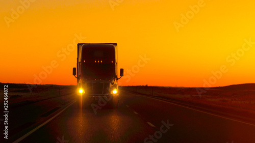 Cuadros en Lienzo CLOSE UP LENS FLARE: Semi truck driving directly into camera at golden sunset