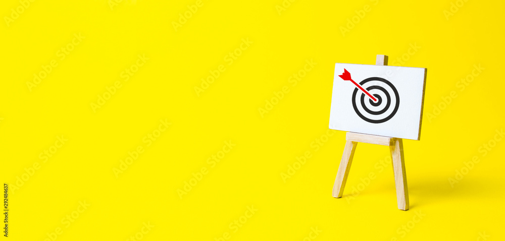 Sign stand with an arrow in the target on a yellow background. Hit exactly on center. Tactics of advertising targeting. advertise campaigns. Goal Achievement and Purposefulness - obrazy, fototapety, plakaty 