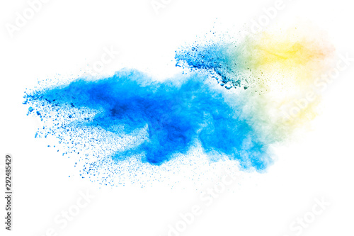 Abstract yellow blue dust explosion on white background. Freeze motion of yel...