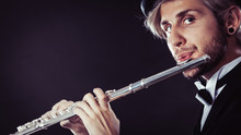 Elegantly Dressed Male Musician Playing Flute