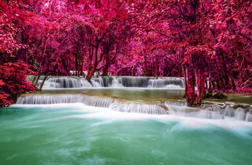 Travel to the beautiful waterfall in tropical rain forest, soft water of the stream in the natural park at Kanchanaburi, Thailand.