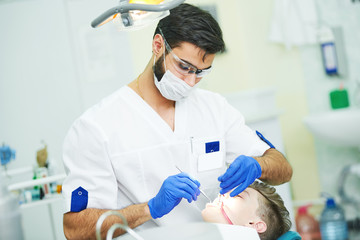 Wall Mural - male dentist at work with young patient