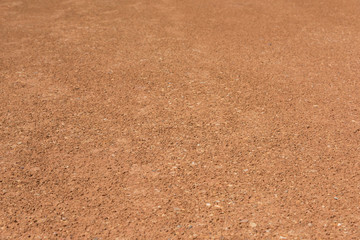 Wall Mural - Flat orange dirt and gravel pavement space close-up