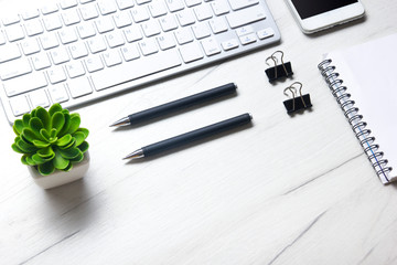 White desk office with laptop, smartphone and other work supplies with cup of coffee. Top view with copy space for input the text. Designer workspace on desk table essential elements on flat lay