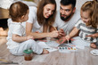 © the faces - nice little baby looking at her parents and elder sister who are spending time on painting. blurred background