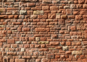 large red old sandstone wall with rough textured surface