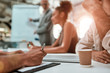 © Kostiantyn - Close up of a coffee cup on the office table. Group of business people having a meeting in the office