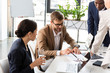 © LIGHTFIELD STUDIOS - partial view of multiethnic businesspeople at table during conference in office