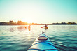 © 6okean - People kayak during sunset in the background. Have fun in your free time.