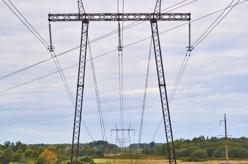 Electric pylon on sky background.Tthe electric line runs through the forest.