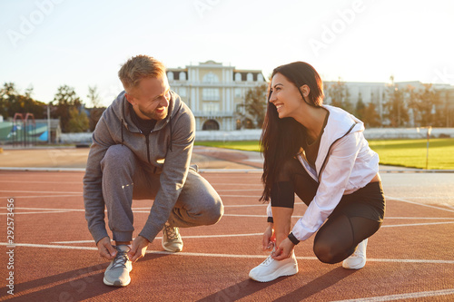 Athletes runners tie shoelaces before training. Poster Mural XXL