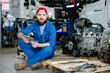 Young bearded worker of machine repair service holding touchpad