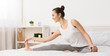 © Prostock-studio - Fit woman stretching legs in her bed early in the morning
