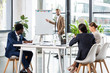 © LIGHTFIELD STUDIOS - selective focus of multiethnic businesspeople sitting at table during conference in office