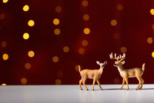 Christmas Holiday Theme With Deer On A Shiny Light Dark Red Background