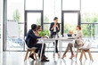 © LIGHTFIELD STUDIOS - multiethnic businesspeople sitting at tables during conference in office