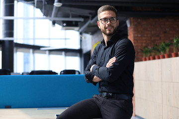 Wall Mural - Portrait of a happy young casual businessman at office