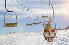 People Riding A Chairlift In A Ski Resort In Winter