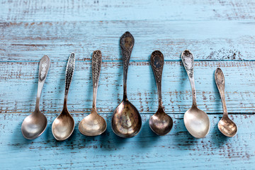 Wall Mural - Vintage cutlery - spoons, forks and knives on an old wooden background.