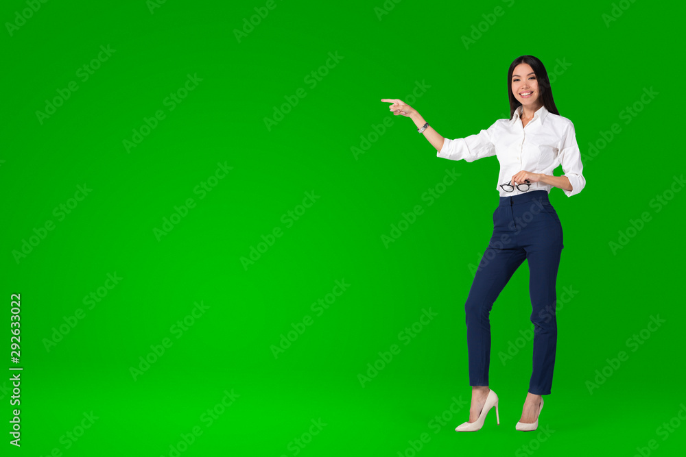 A beautiful young asian woman, anchor or tv presenter is getting filmed inside a green screen chroma key studio to create a video with removable background that can be replaced - obrazy, fototapety, plakaty 