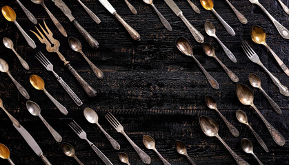 Wall Mural - Vintage cutlery - spoons, forks and knives on an old wooden background.