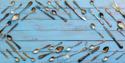 Wall Mural - Vintage cutlery - spoons, forks and knives on an old wooden background.