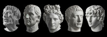 Five Gypsum Copy Of Ancient Statue Heads Isolated On A Black Background. Plaster Sculpture Mans Faces.