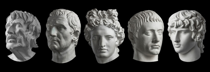 Five gypsum copy of ancient statue heads isolated on a black background. Plaster sculpture mans faces.