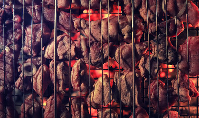 Wall Mural - Slices of chopped meat in a grate for cooking barbecue on charcoal in the oven. Meat on the grill. Shish kebab in the oven on an open fire.