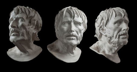 Three gypsum copy of ancient statue head of Lucius Seneca isolated on black background. Plaster sculpture aged man face.