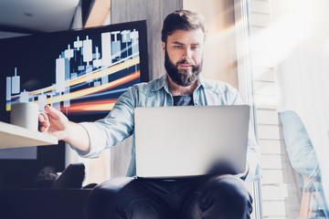 Office worker sitting at desk with laptop on knees. Freelance developer and designer at work. Digital solutions, products and programs for creative personnel. Man checking email and watching webinar.