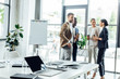 © LIGHTFIELD STUDIOS - selective focus of businesspeople holding disposable cups of coffee and workspace on foreground
