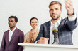© LIGHTFIELD STUDIOS - selective focus of multiethnic businesspeople in formal wear clapping and smiling during conference