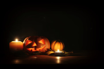 holidays image of halloween. Pumpkins over wooden table dark background