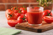 Tasty Tomato juice in a glass with ripe red tomatoes.