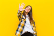 © kues1 - young  pretty woman smiling and looking friendly, showing number five or fifth with hand forward, counting down against orange wall