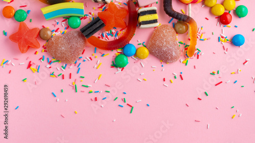 mixed colorful sweet candies with jelly over pink like festive background, co...