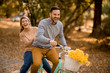 © BGStock72 - Active young couple enjoying together in riding bicycle in golden autumn park