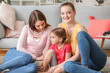 © Pixel-Shot - Happy lesbian couple with little daughter at home